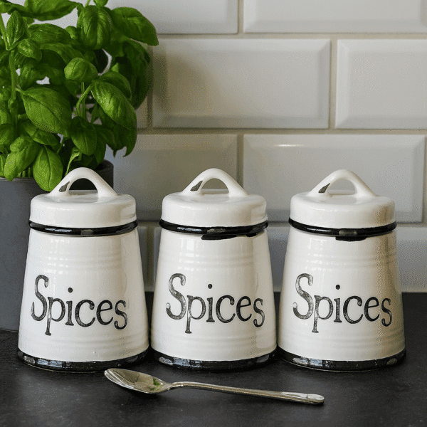 Keramikburkar för kryddor i set om tre, vita med svarta distressed detaljer och texten Spices. Höjd 11 cm. Praktisk och dekorativ förvaring till köket.