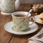 Kopp med fat i porslin med William Morris mönster Golden Lily. Rymmer 200 ml. Tål maskindisk och mikro, perfekt för kaffe och te.