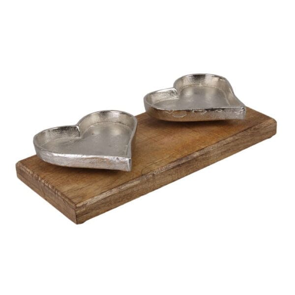 Hjärtformade ljusfat i aluminium med en fot av trä. Mått 14x32 cm.