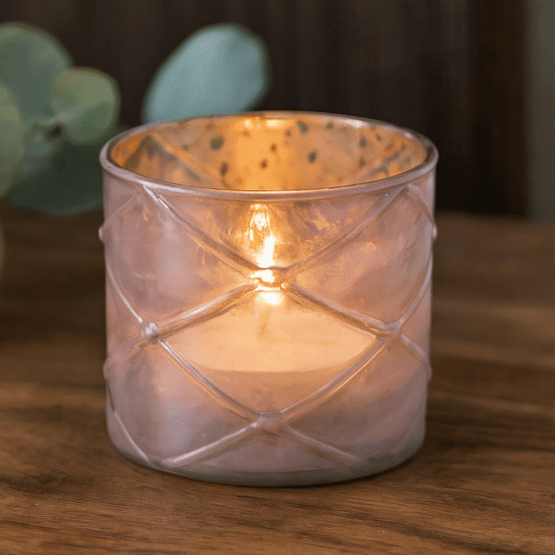 Ljuslykta i rosa glas med diskret rutmönster och antik finish. Sprider ett mjukt, varmt sken och passar lika fint ensam som i grupp. Diameter 9 cm, höjd 8 cm.