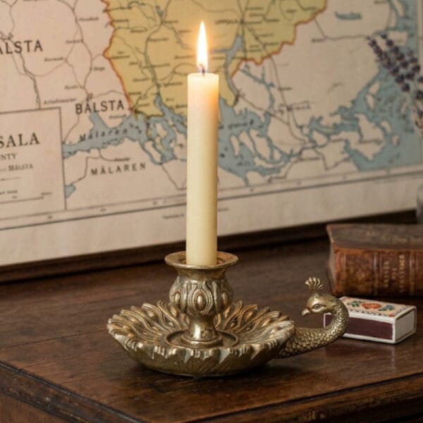 Ljusstake med påfågel i guldfärgad polyresin. Dekorativ och elegant ljusstake för kronljus som passar både dukning och inredning.