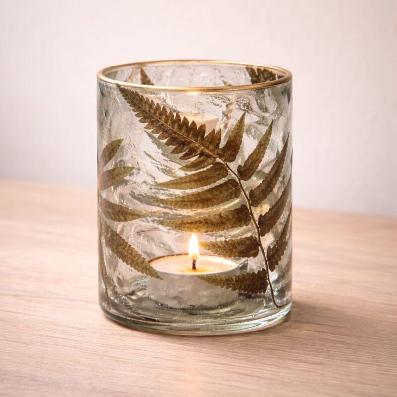 Vacker ljuslykta i glas med ingjutna växter som skapar ett levande och naturligt mönster. Ger ett mjukt sken med värmeljus. Diameter 10 cm, höjd 13 cm.