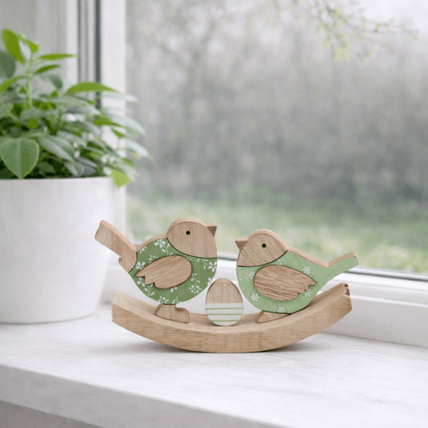 Träfåglar 20 cm med gröna målade detaljer och dekorativt ägg på rundad bas. En stämningsfull påskdekoration i trä som sprider mjuk vårkänsla i hemmet.